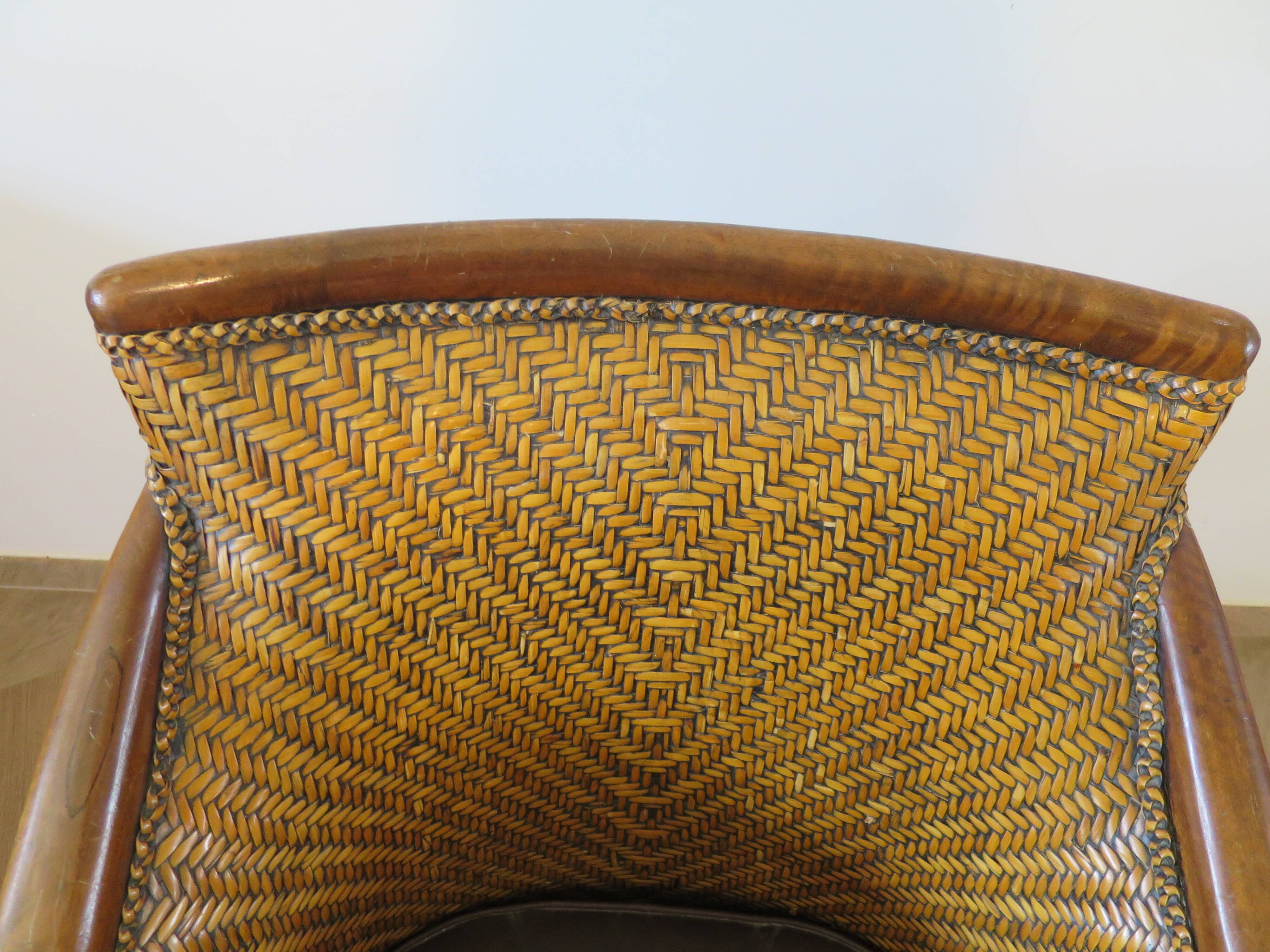 Colonial style armchair in woven rattan and exotic wood