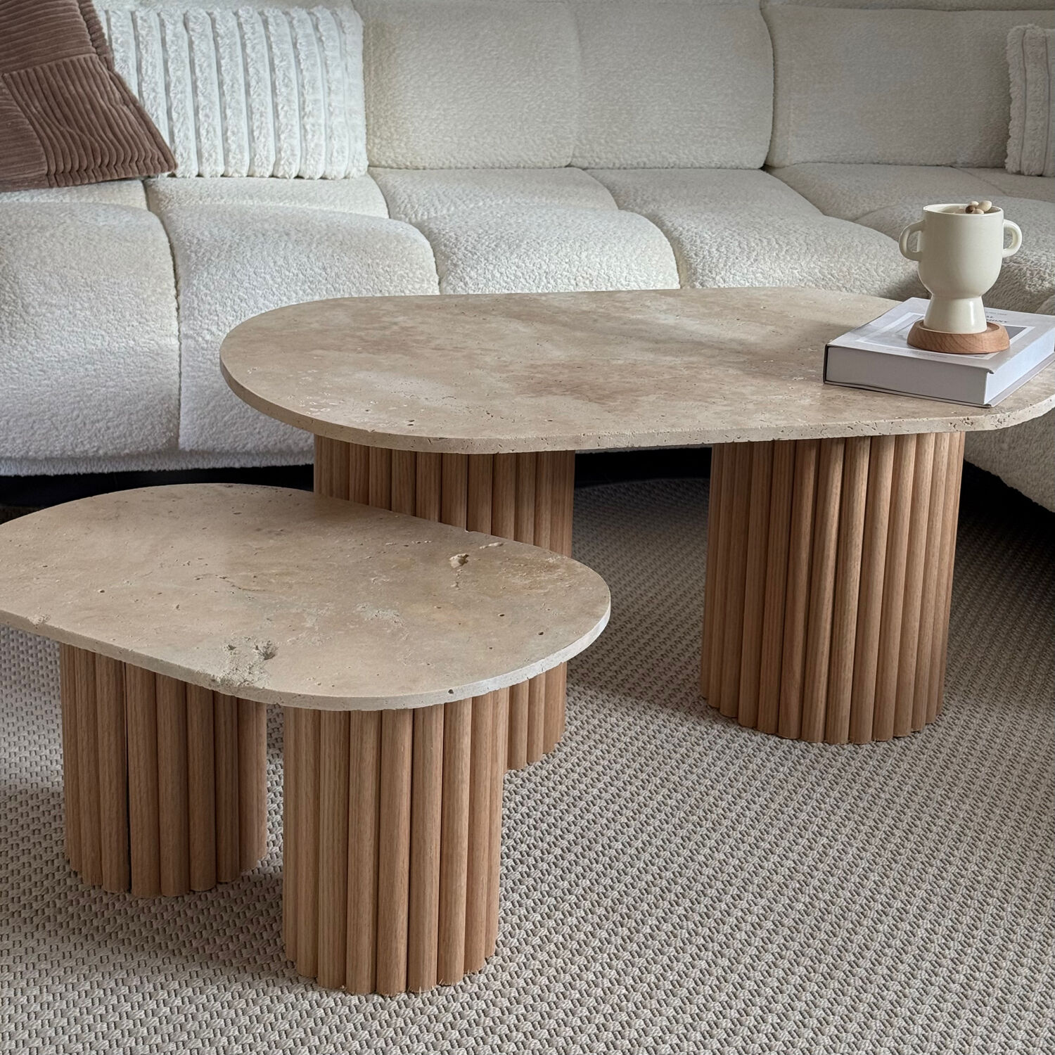 Oval coffee table duo travertine and raw fluted wooden legs.