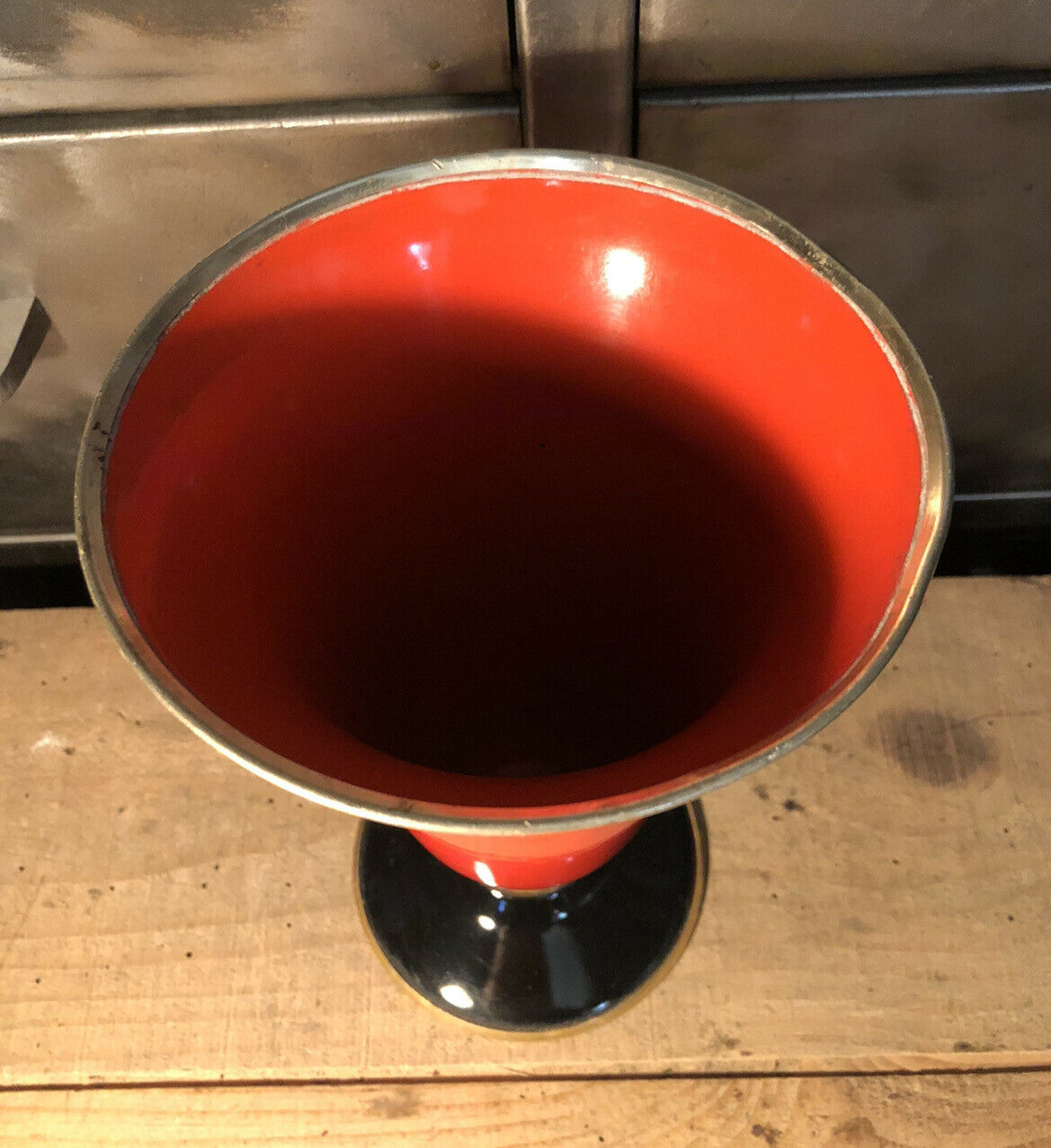 Cut vase on foot in red and black metal