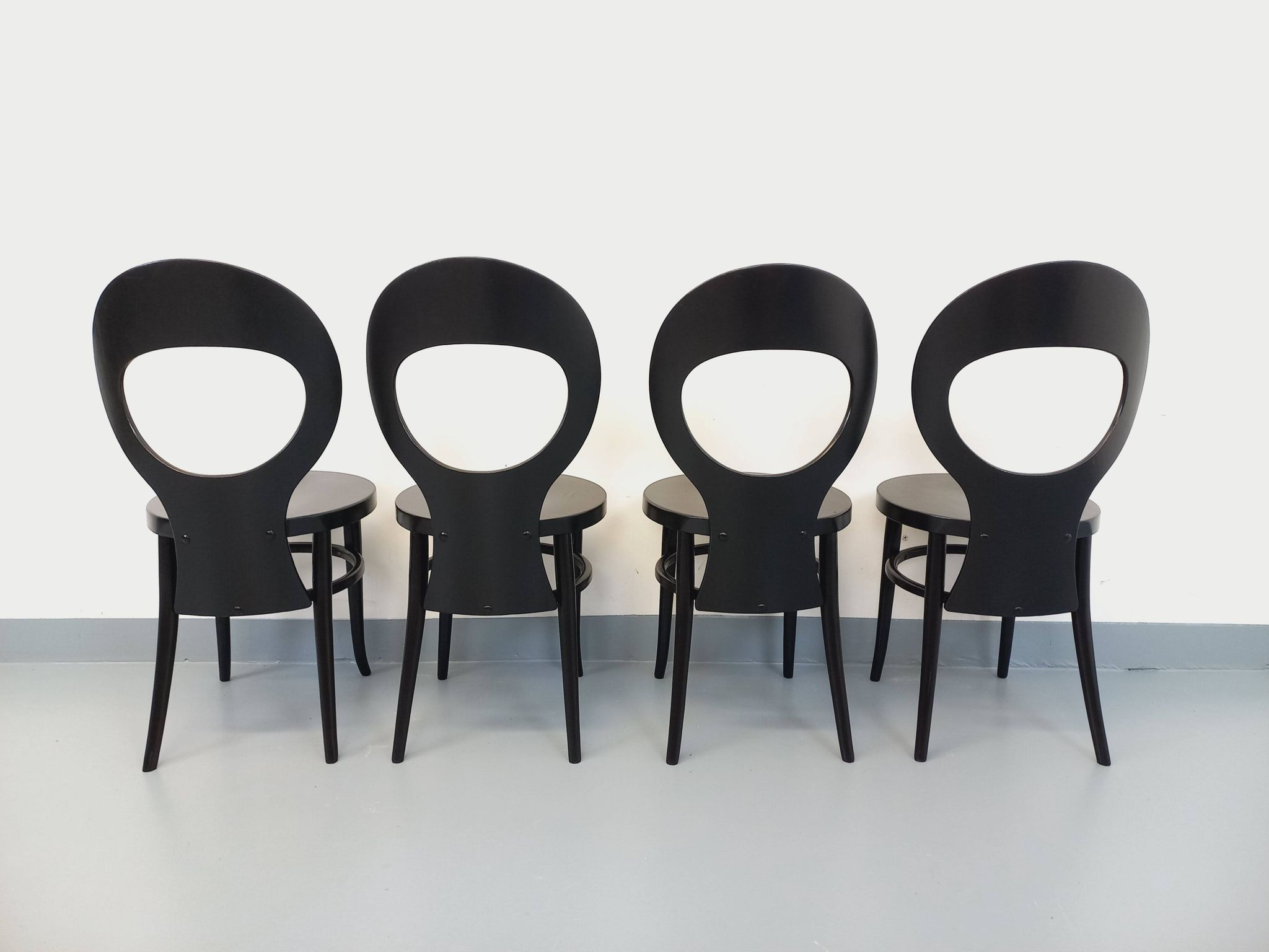 Set of 4 vintage Mouette chairs by Baumann in black wood from the 1960s.