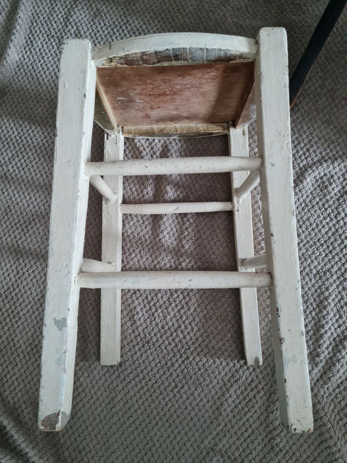 Vintage wooden stool with white peeling paint