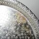 Small Moroccan tripod tea tray in silver-plated metal, vintage chiseled decoration.