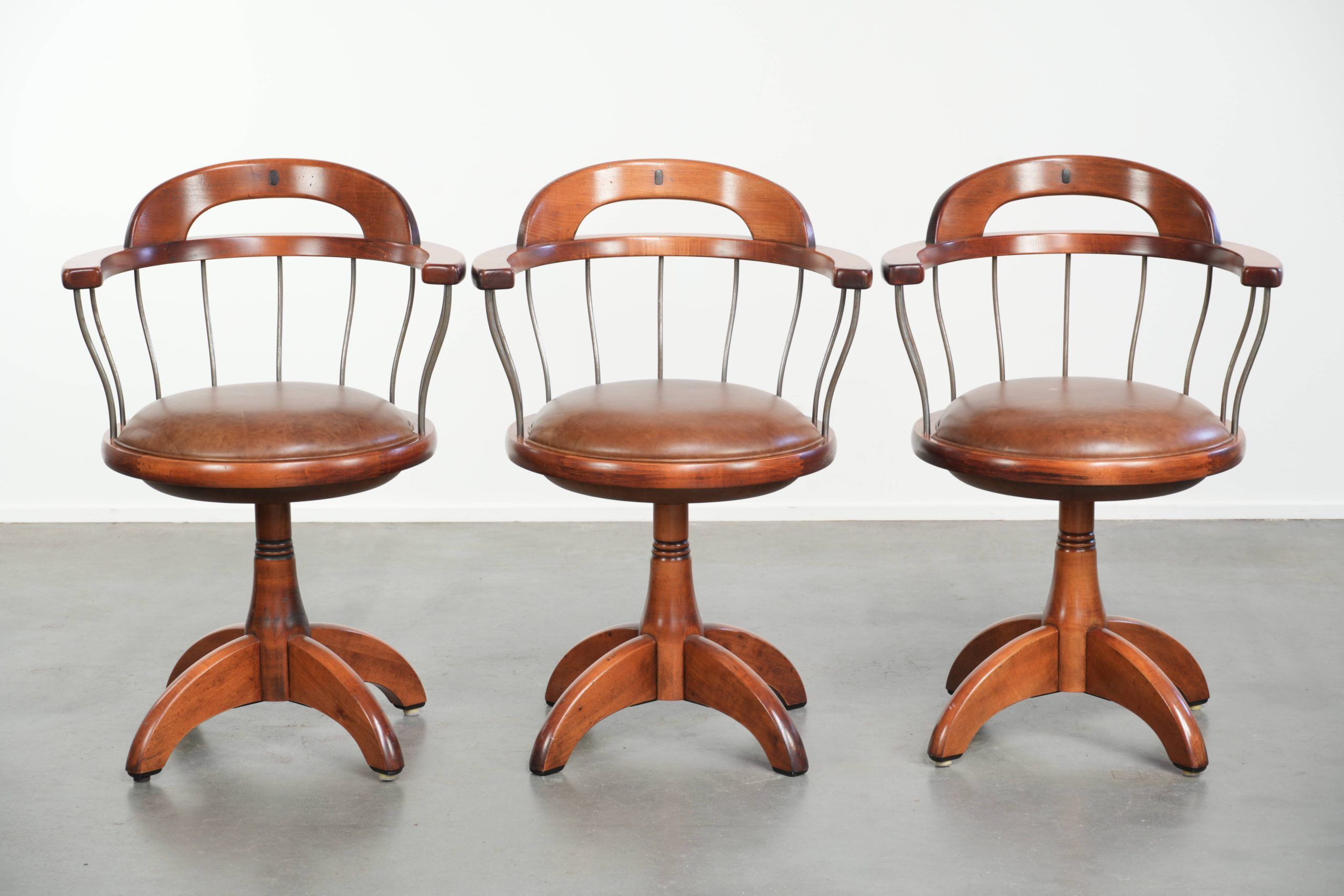 Ensemble de 3 chaises de bureau / de côté pivotantes avec un siège en cuir de vache couleur cognac.
