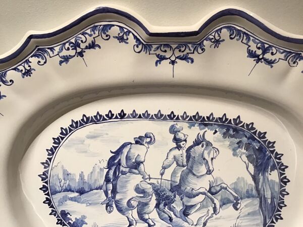 Plat ovale en faïence à décor d’une scène de chasse signée