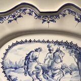 Oval plat in earthenware decorated with a hunting scene signed