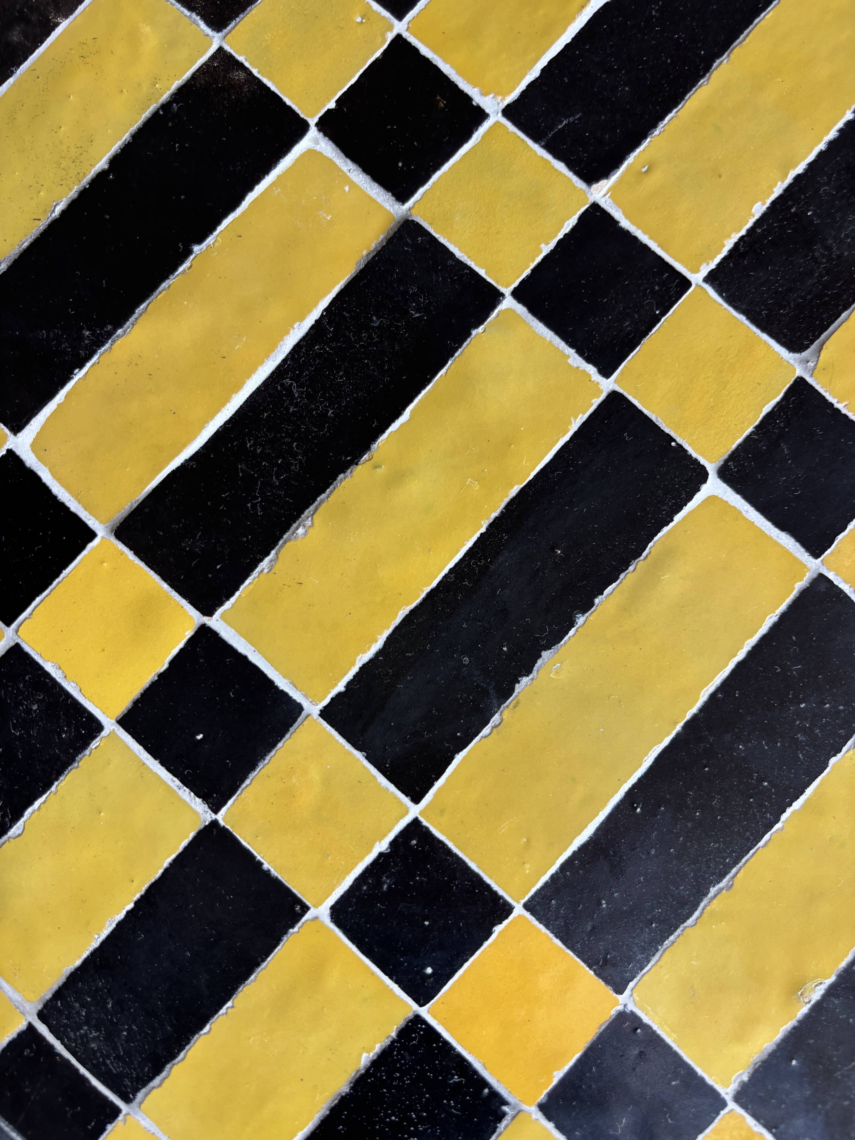 Round coffee table in yellow and black zellige, Moroccan graphic pattern.
