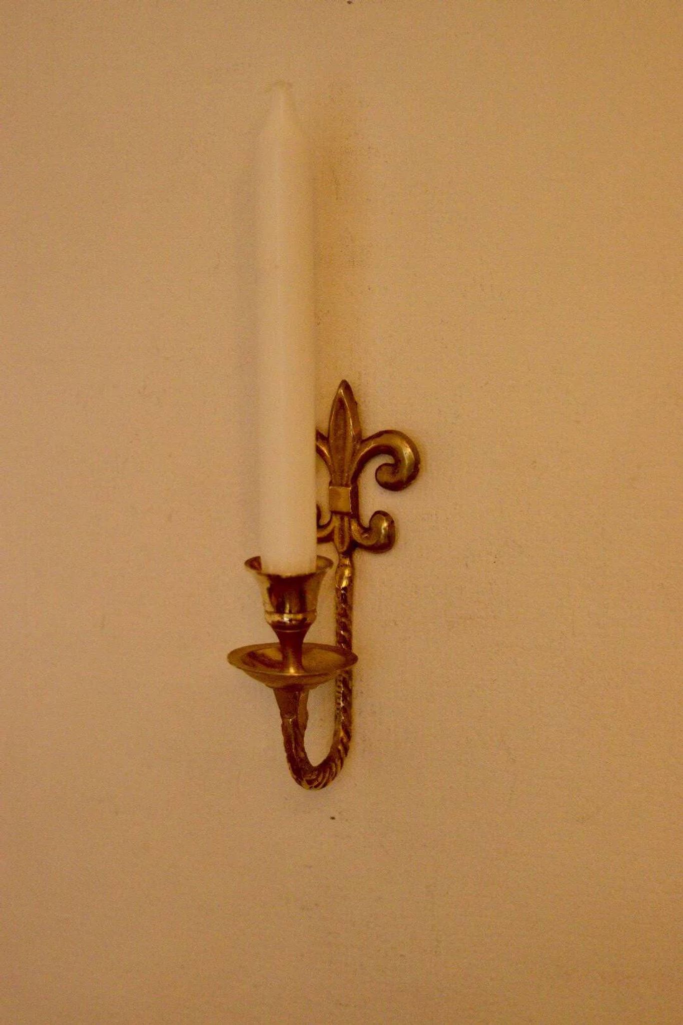 A pair of antique brass wall sconces.