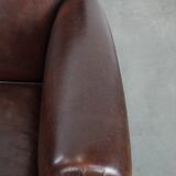 Sheepskin armchair with a classic finish and decorative studs.