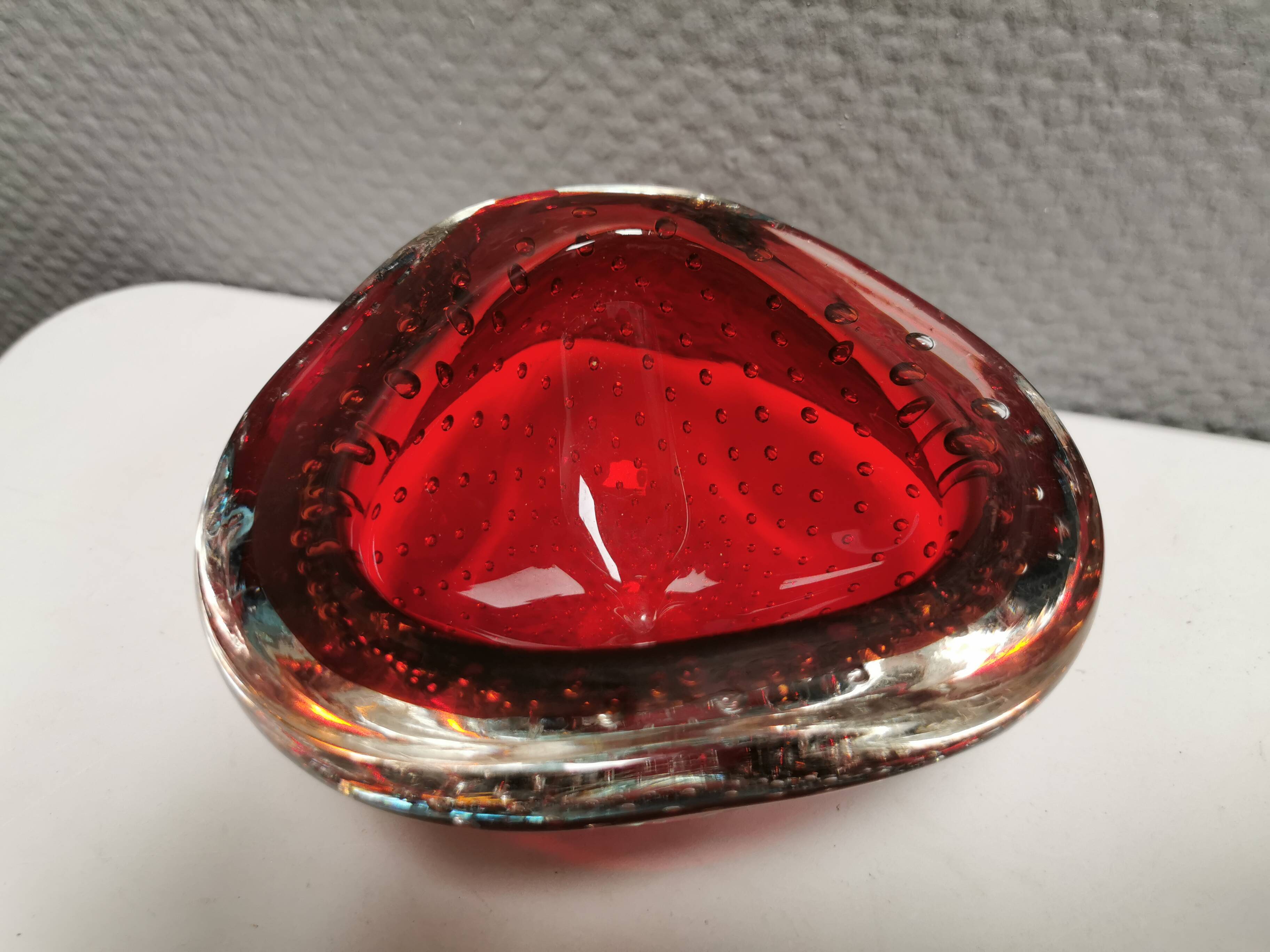 Small glass bowl in beautiful emerald red color with inlaid bubbles.