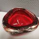 Small glass bowl in beautiful emerald red color with inlaid bubbles.