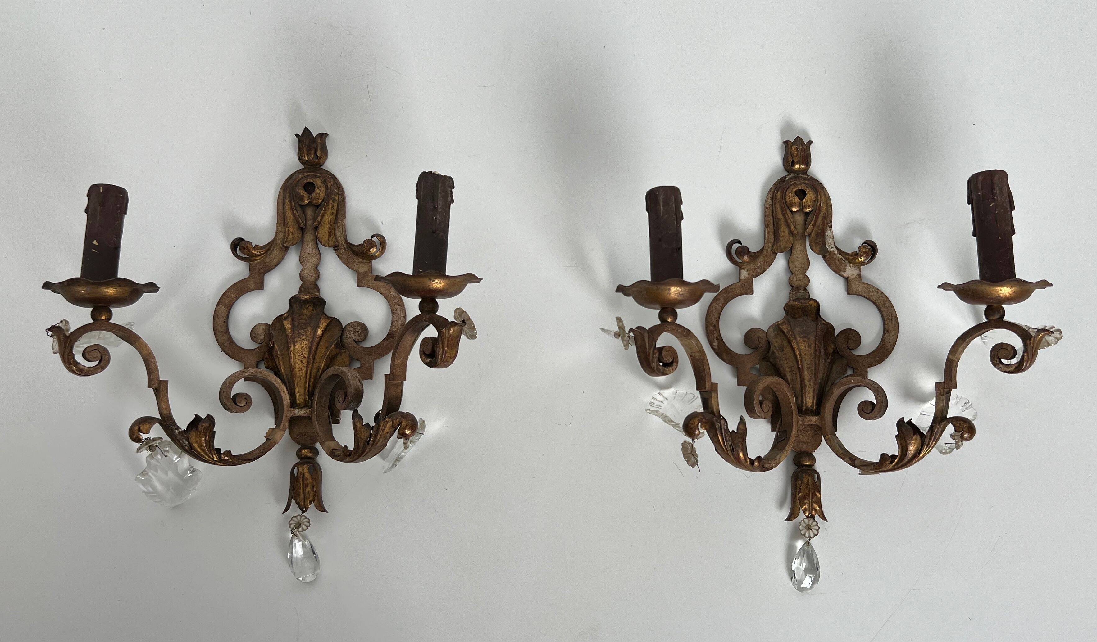 Pair of patinated wrought iron wall sconces with golden acanthus leaves and crystals.
