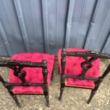 Pair of black lacquered chairs with purple tufted upholstery.