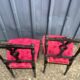 Pair of black lacquered chairs with purple tufted upholstery.