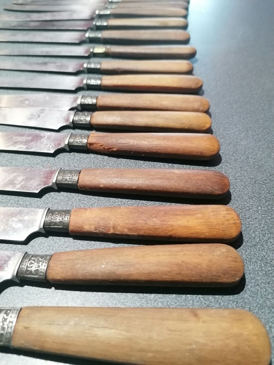 Old table knives and dessert knives, wooden handles, stainless steel blades