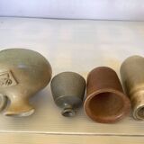 Seven beige and gray ceramic vases
