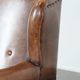 Sheepskin wingback armchair with decorative nails and black piping