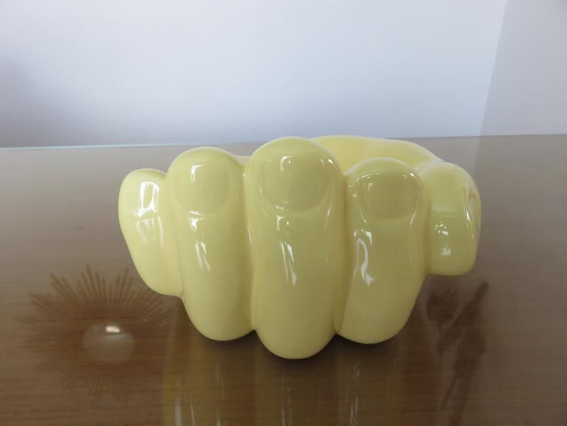 Empty hand-shaped pocket in pale yellow ceramic years70