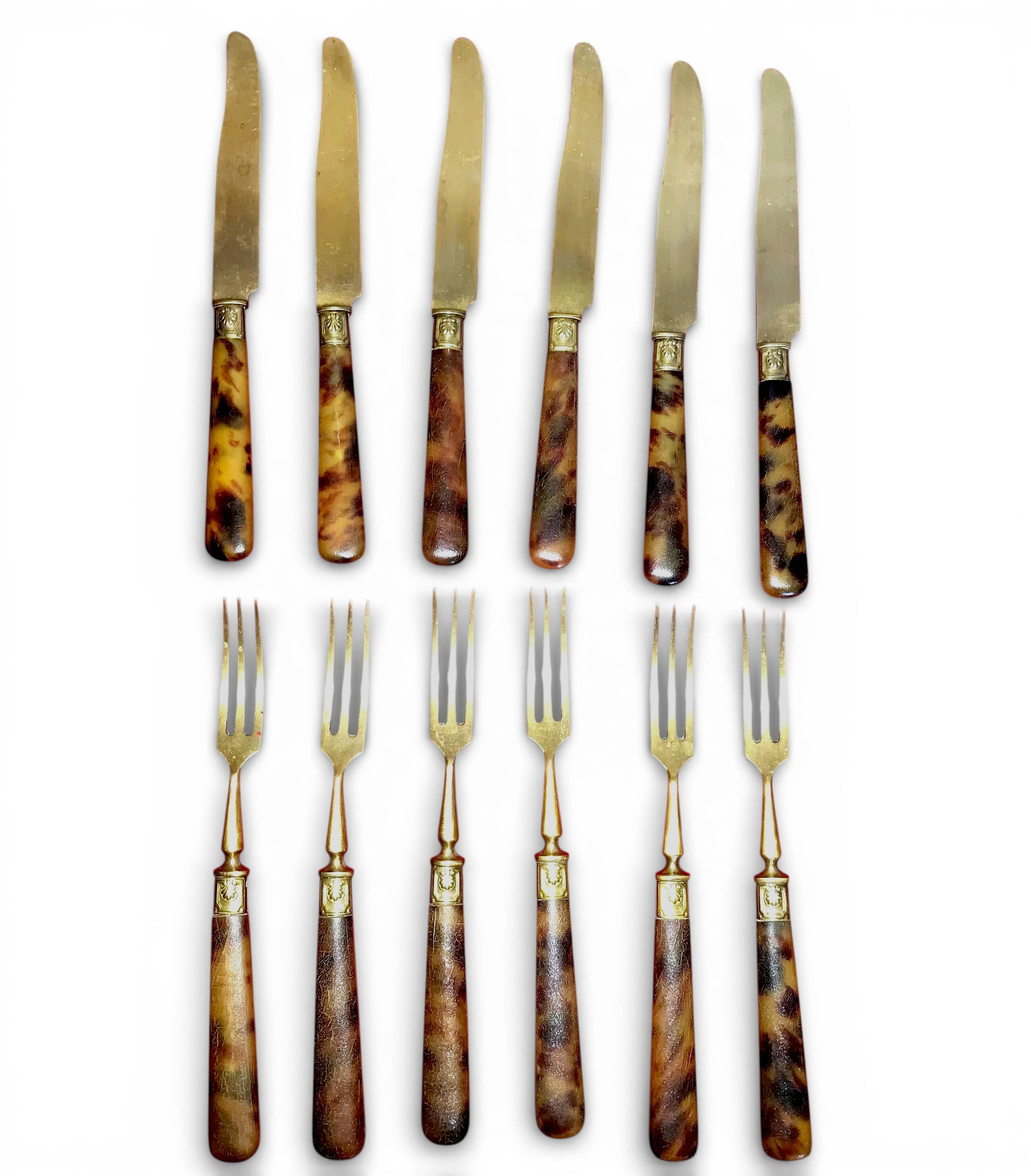 Table art, 12 fruit cutlery sets in gilded metal with horn from the early 20th century.