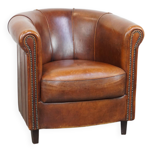 Fauteuil club en cuir de mouton de couleur cognac et finition passepoilée