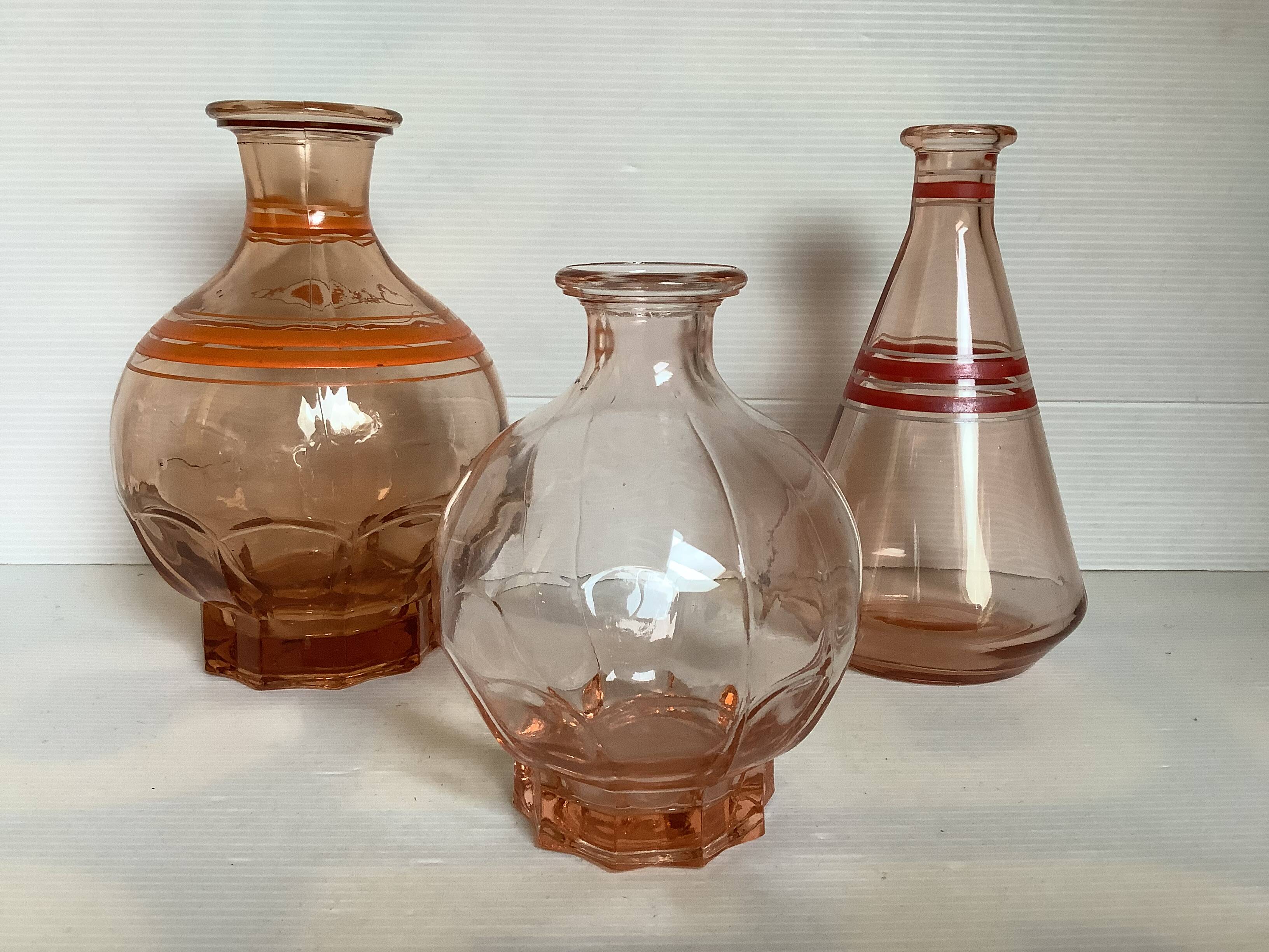 Trio of pink bottle decanters