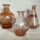 Trio of pink bottle decanters