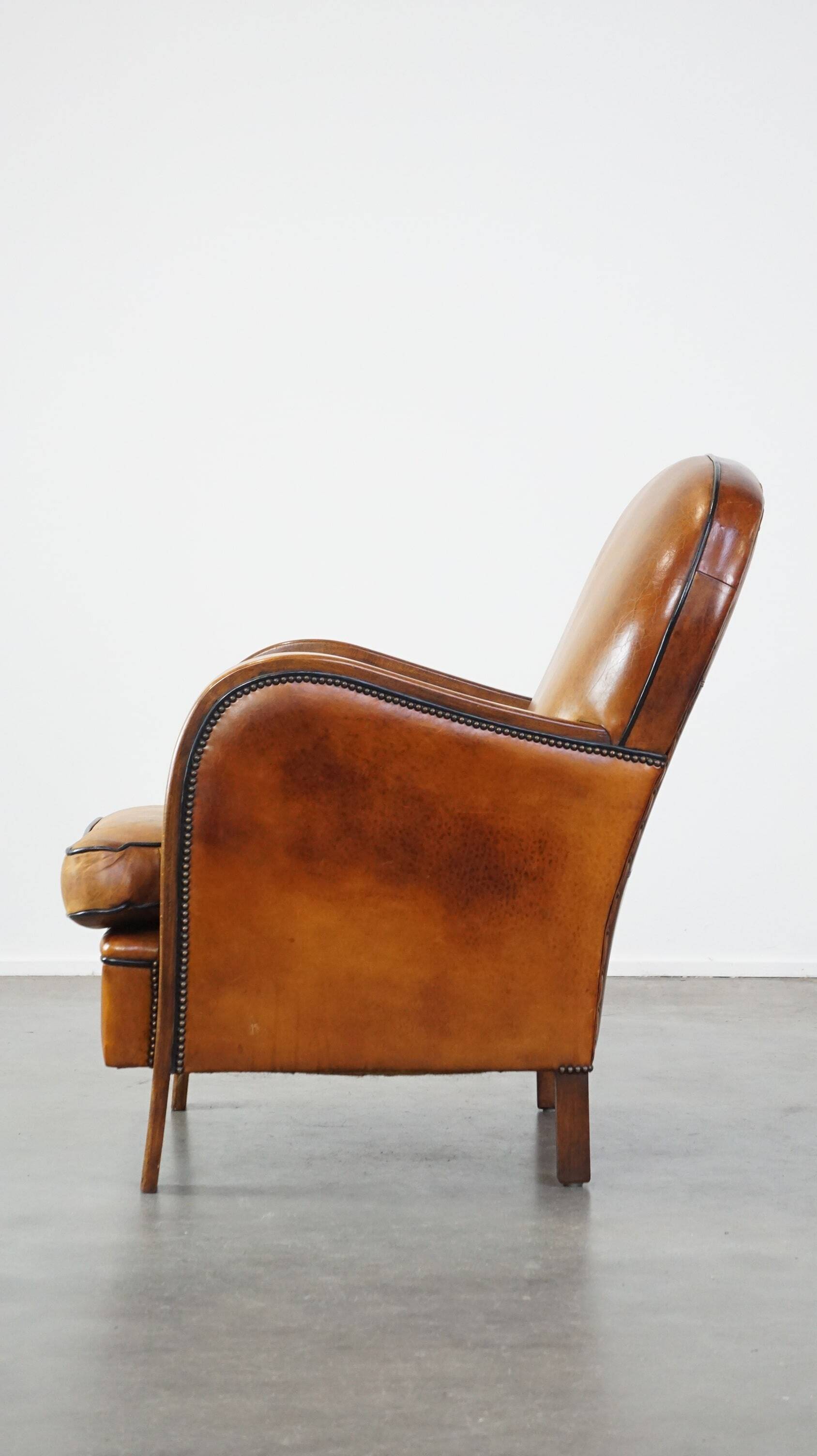 Unique, luxurious sheepskin armchair combined with wood and finished with decorative nails