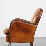 Unique, luxurious sheepskin armchair combined with wood and finished with decorative nails