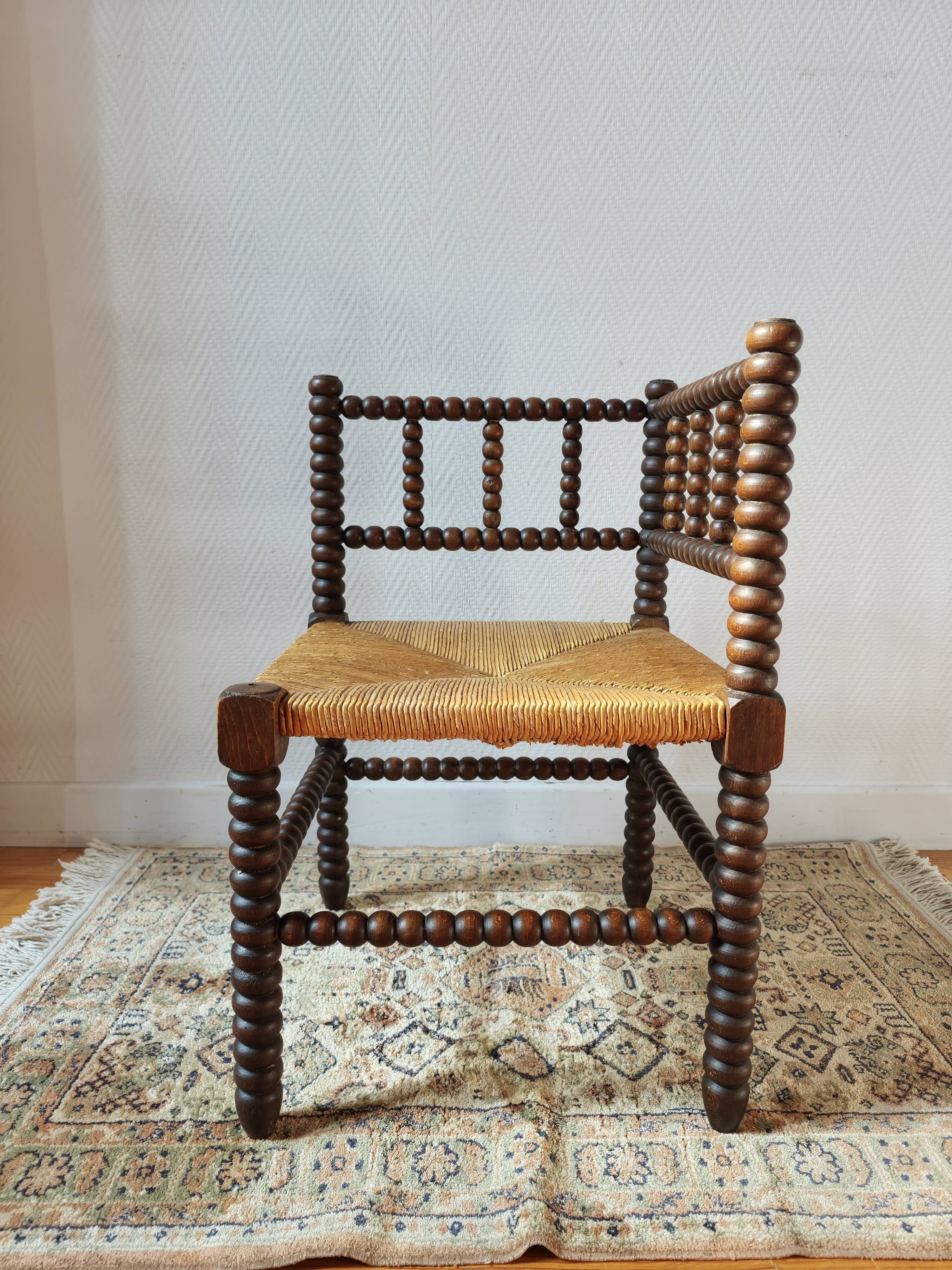Old wooden turned spindle fireside chair with a straw seat.