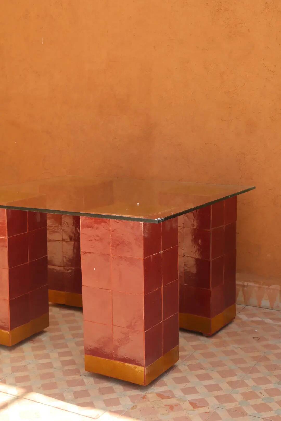 Modern coffee table in burgundy zellige with a tempered glass top.