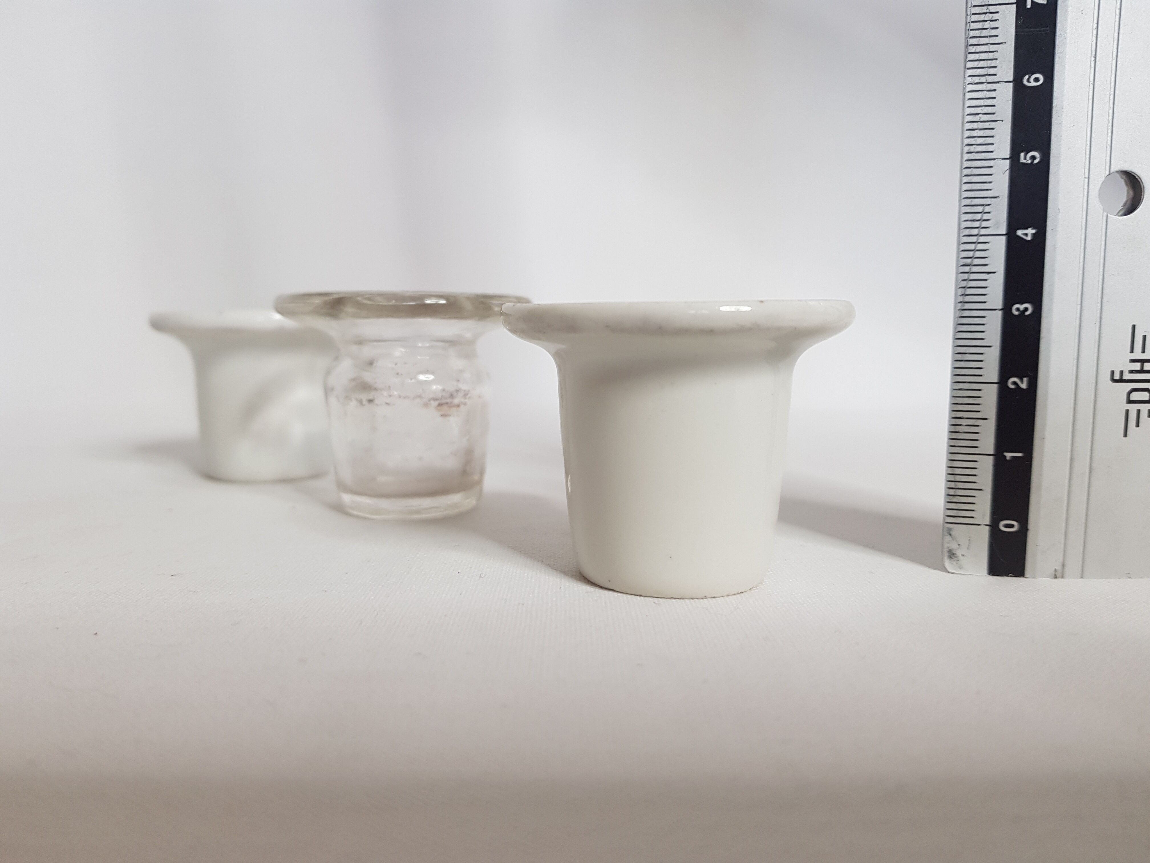 Three white porcelain and glass inkwells for school desk