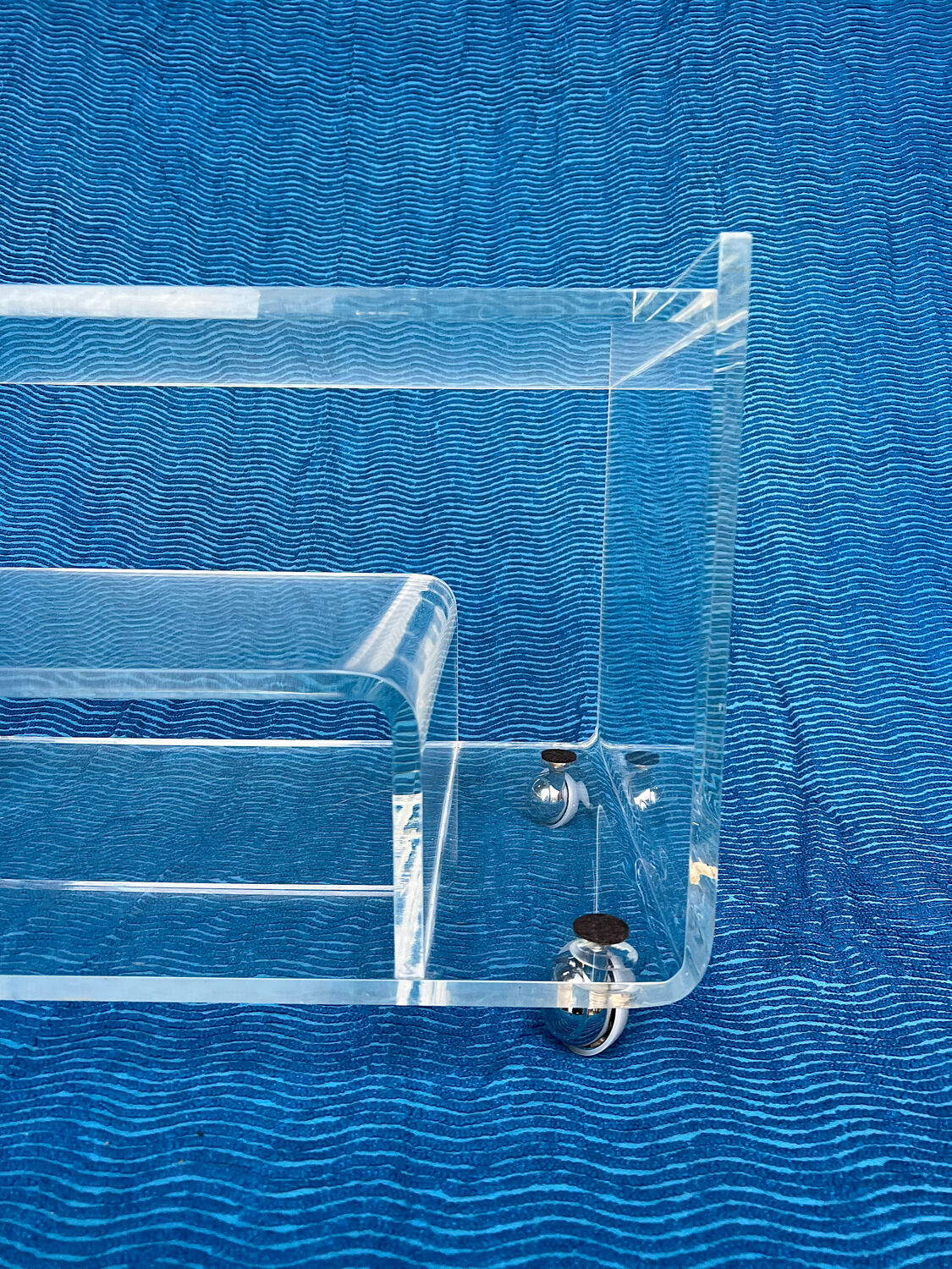Translucent plexiglass storage drawer/cabinet on wheels.