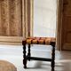 Antique turned wooden stool with woven leather.