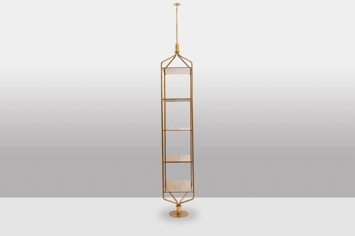 Free-standing shelf in gilded brass with smoked glass shelves. 1970s.