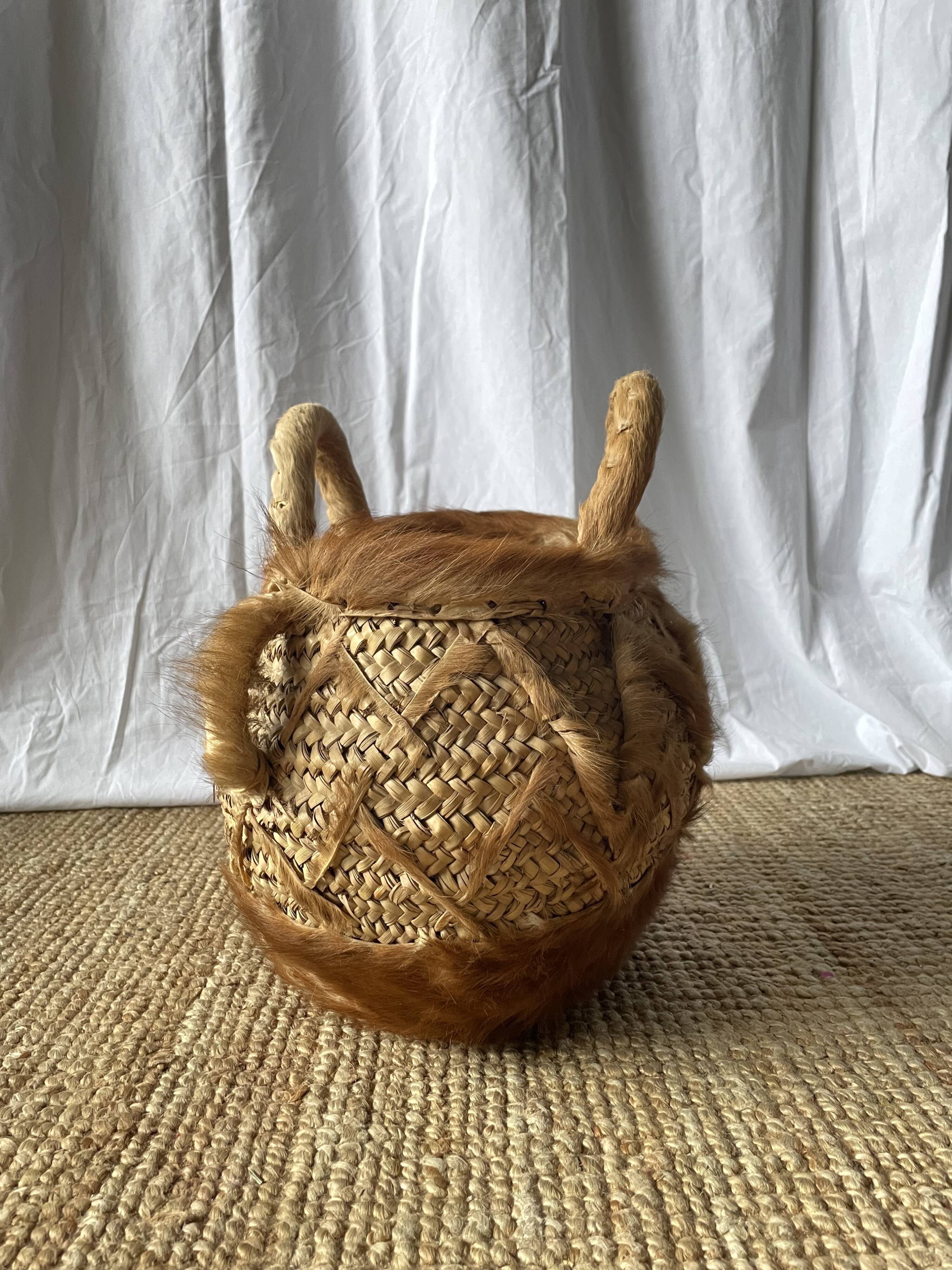 Handwoven vintage basket with handles made from natural fibres.