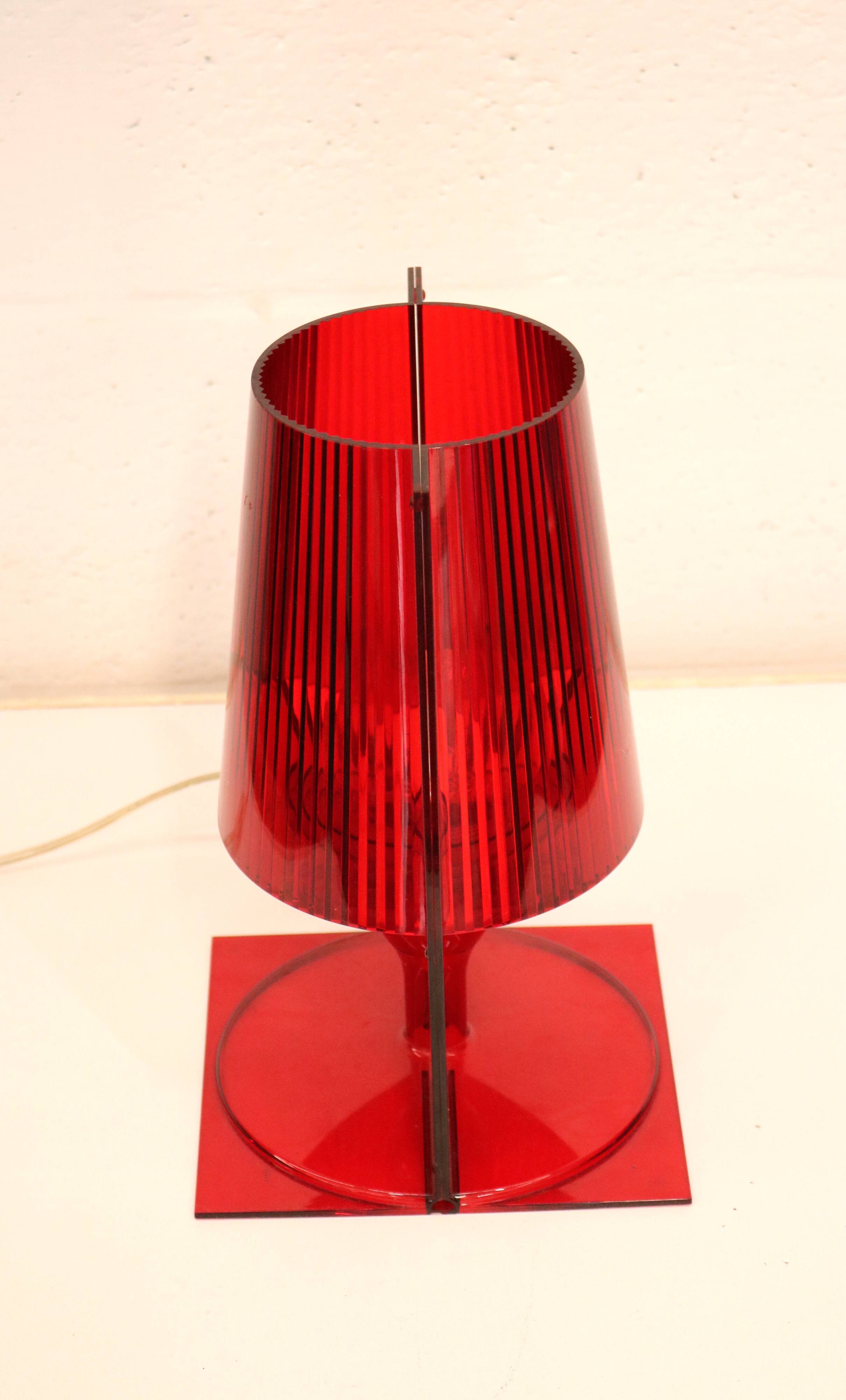 Red plastic Kartell table lamp - model Take - design by Ferruccio Laviani