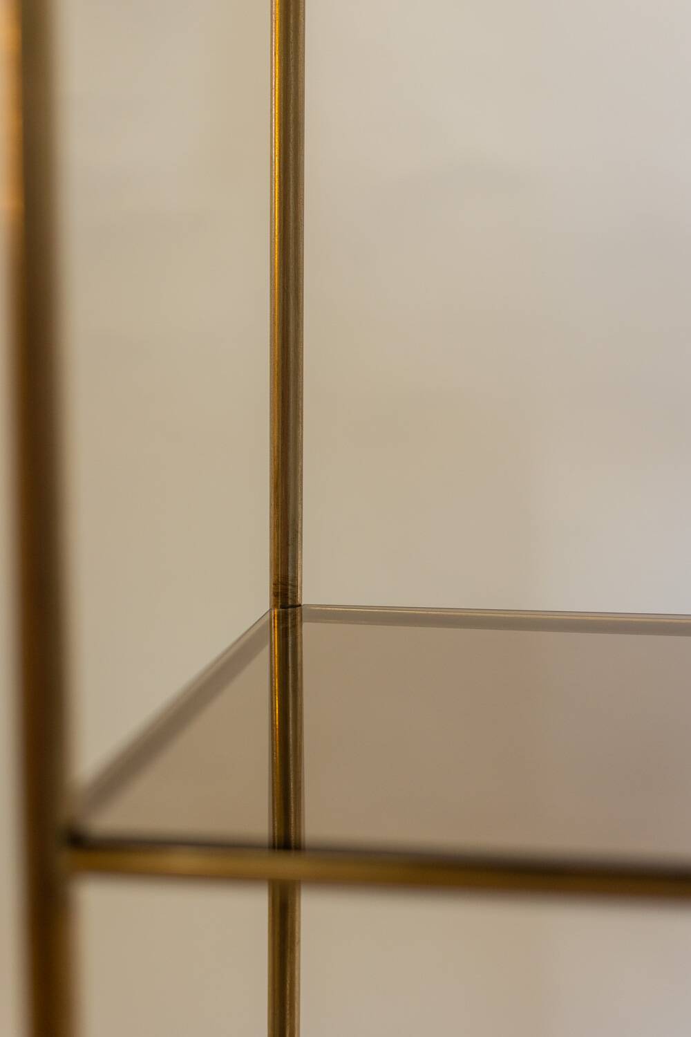 Free-standing shelf in gilded brass with smoked glass shelves. 1970s.