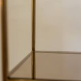 Free-standing shelf in gilded brass with smoked glass shelves. 1970s.