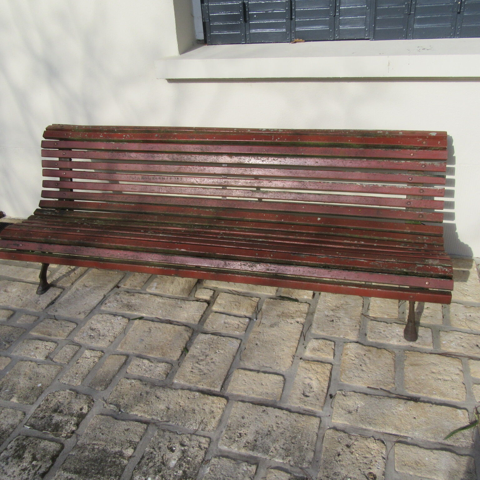 Public bench in wooden slats and cast iron legs