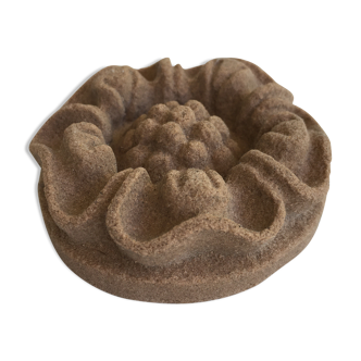 Pink sandstone paperweight in the shape of a rosette