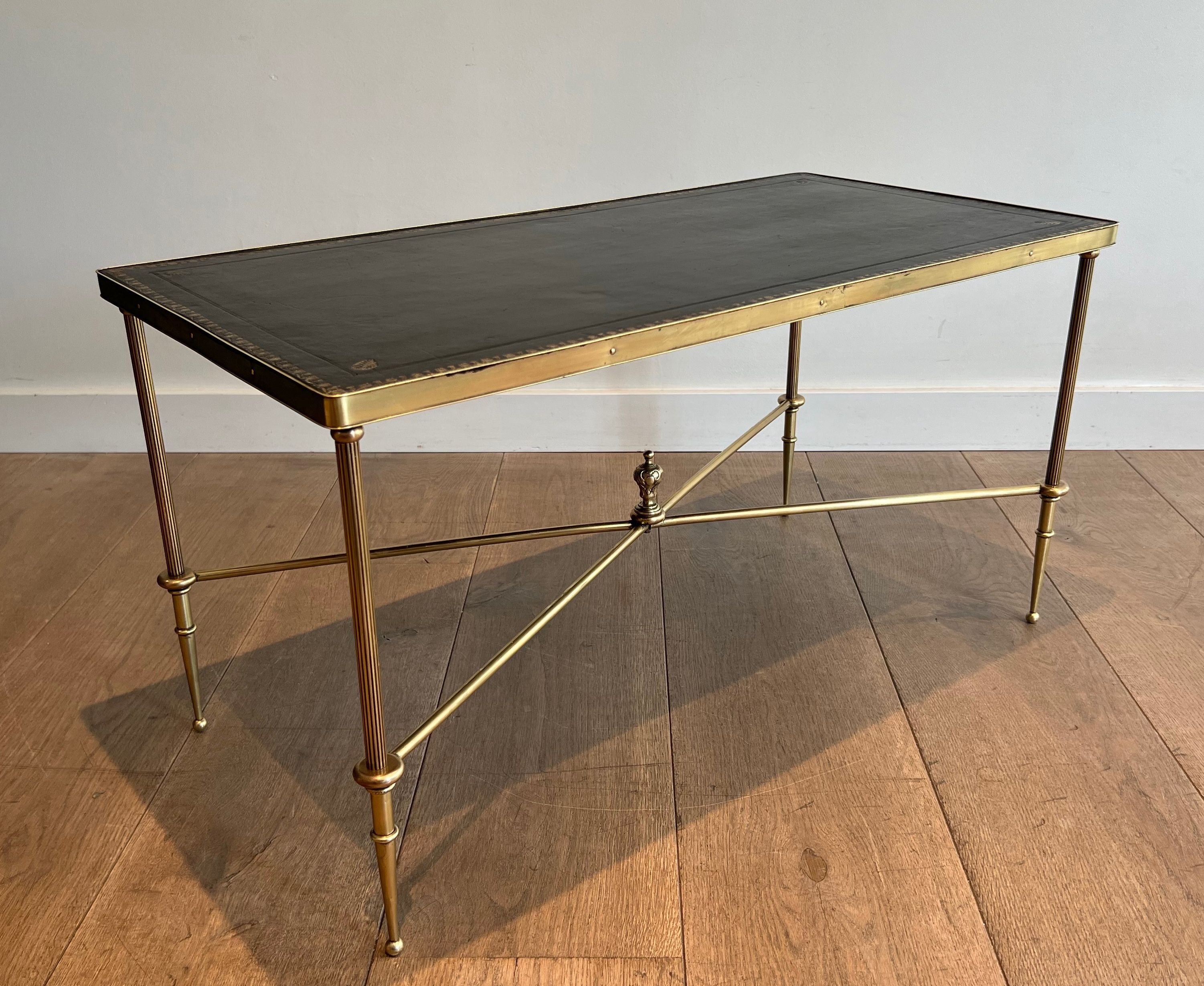 Neoclassical brass coffee table with a black leather top and golden borders from Maison Jansen.