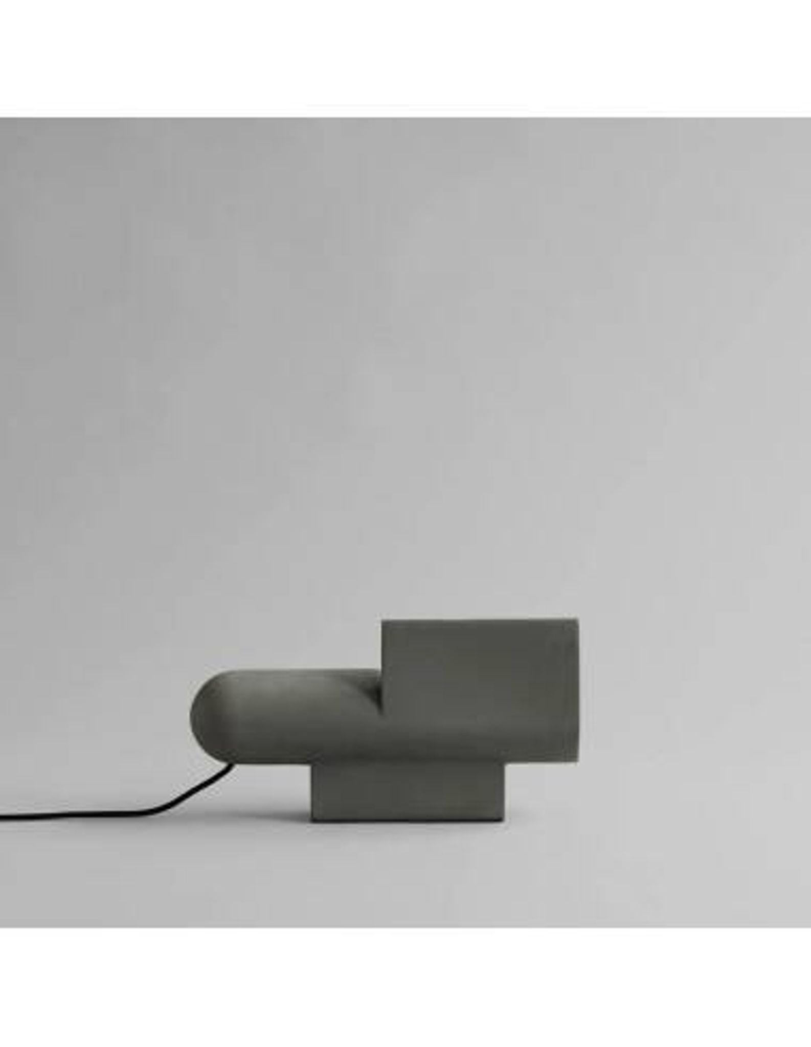 Lampe de table brutaliste en béton, œuvre contemporaine.