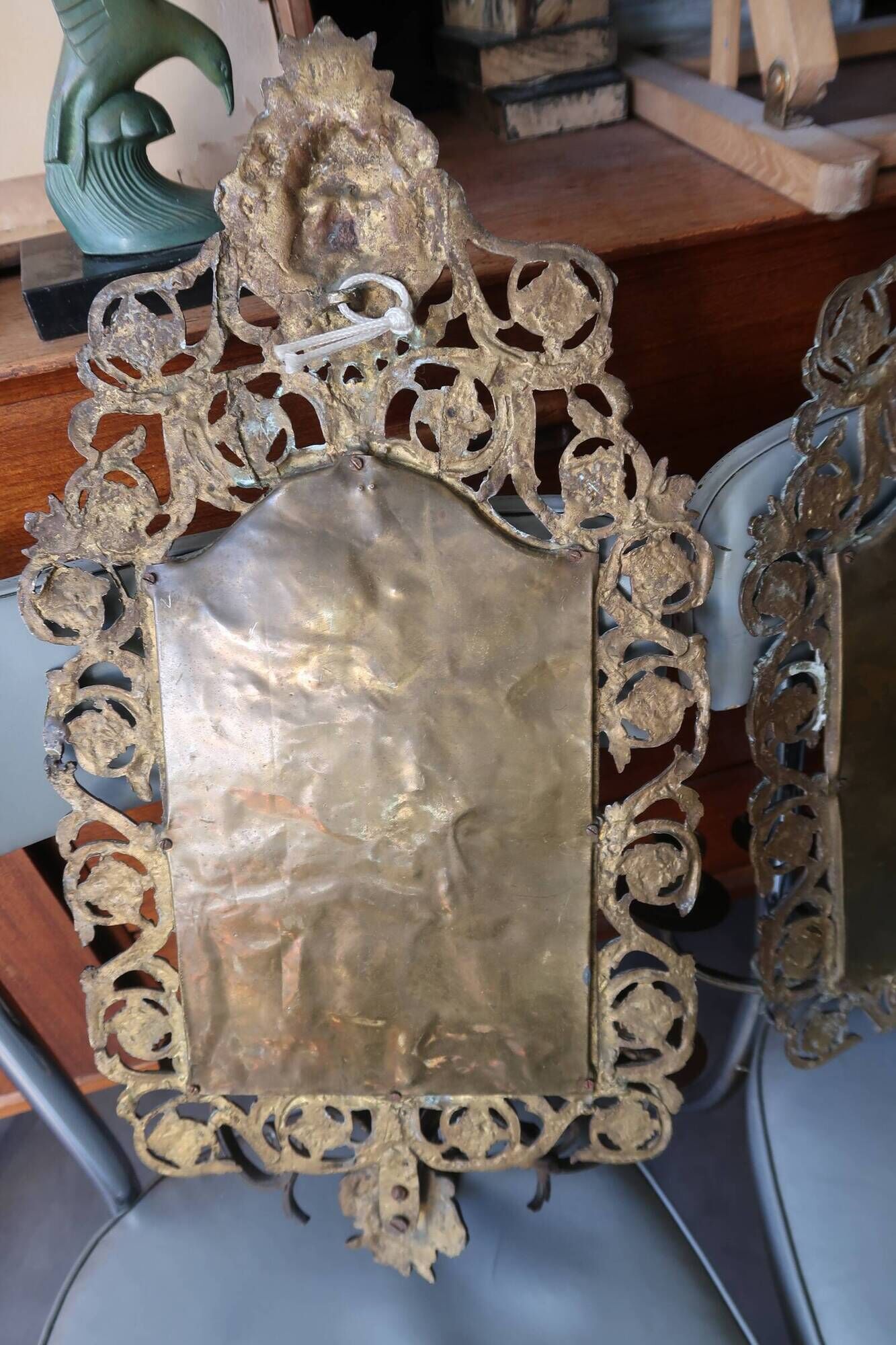 Pair of mirror wall sconces with brass candle holders.