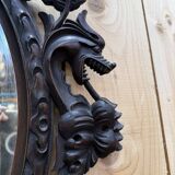 Oval mirror in carved wood with dragon heads.