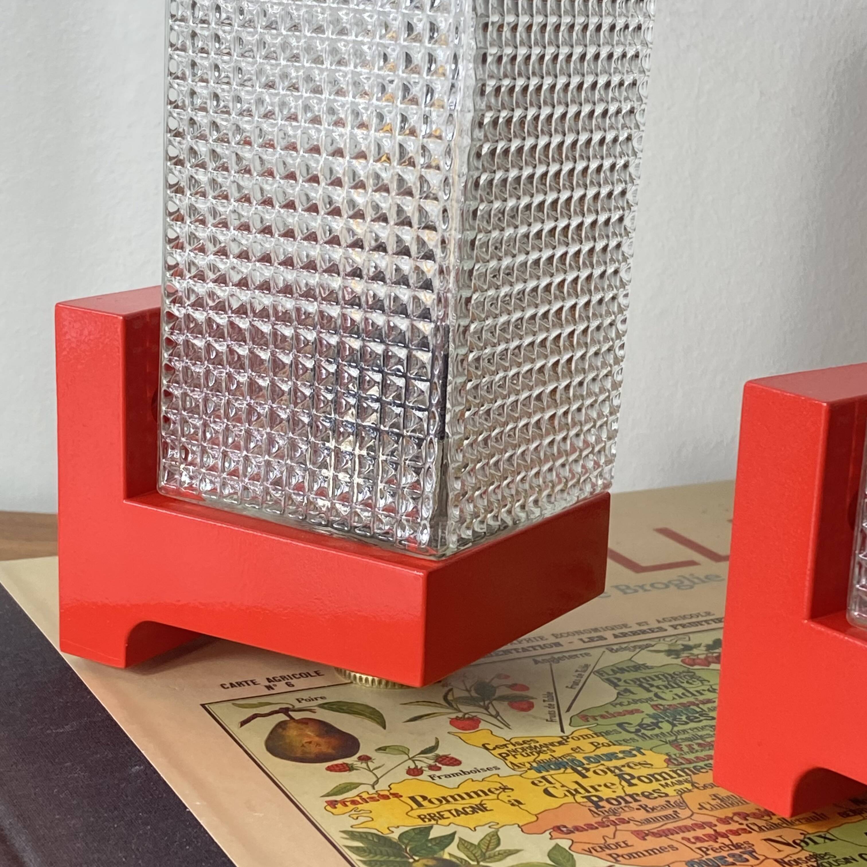 Pair of vintage wall lights in red plastic and clear glass.