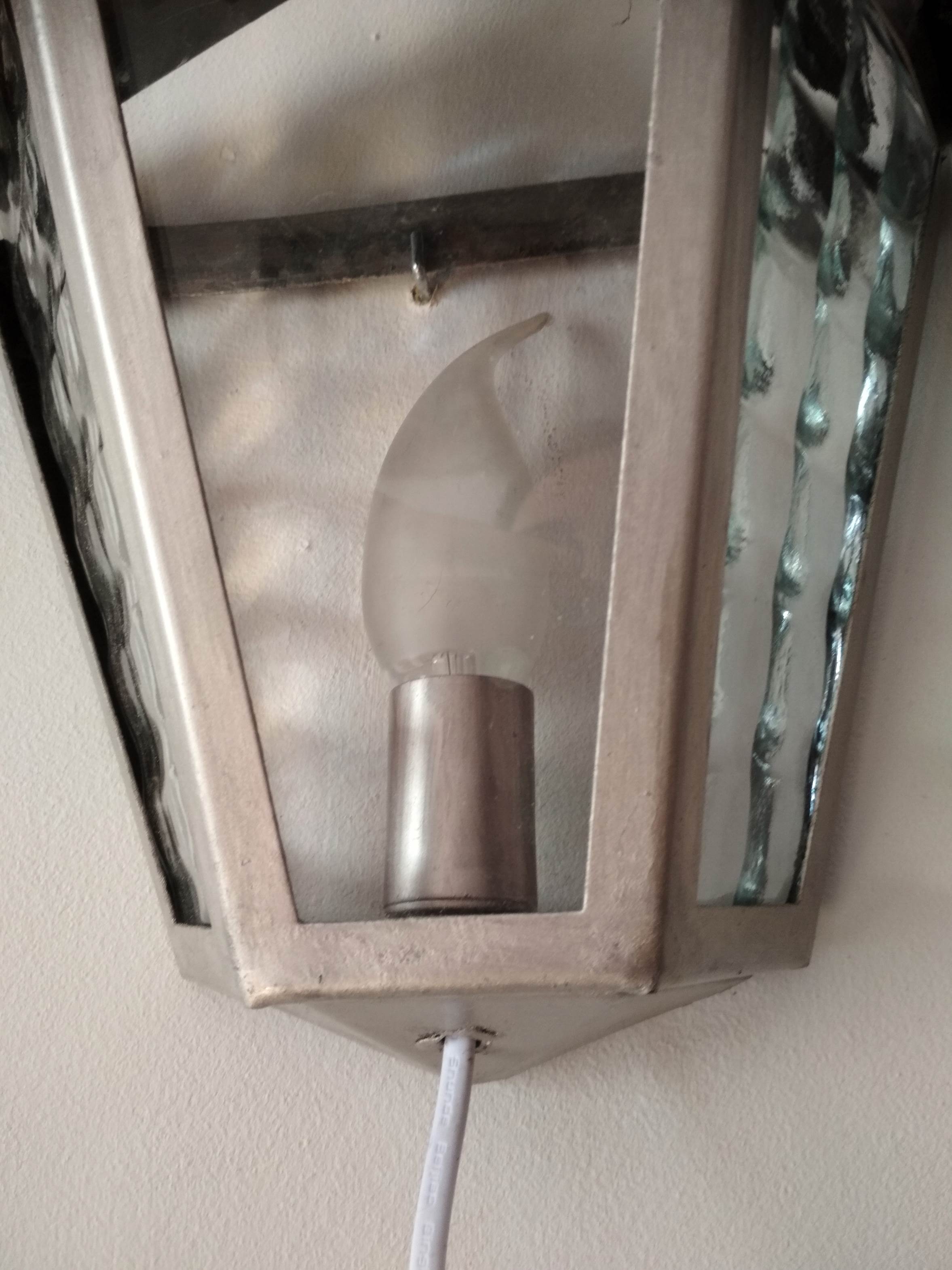 Half grey metal wall sconce and 3 windows