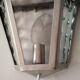 Half grey metal wall sconce and 3 windows