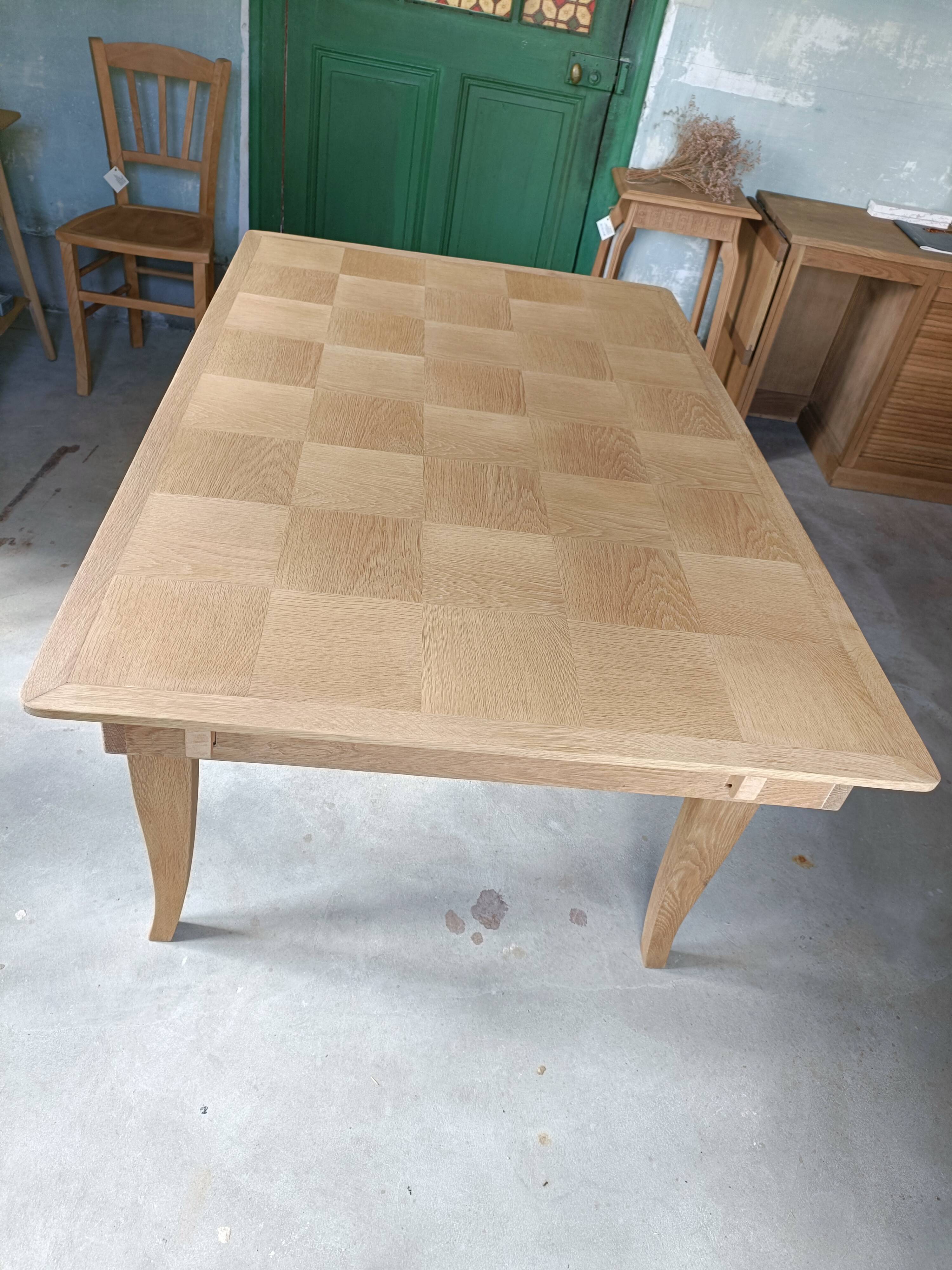Oak dining table with a checkerboard top and extensions.