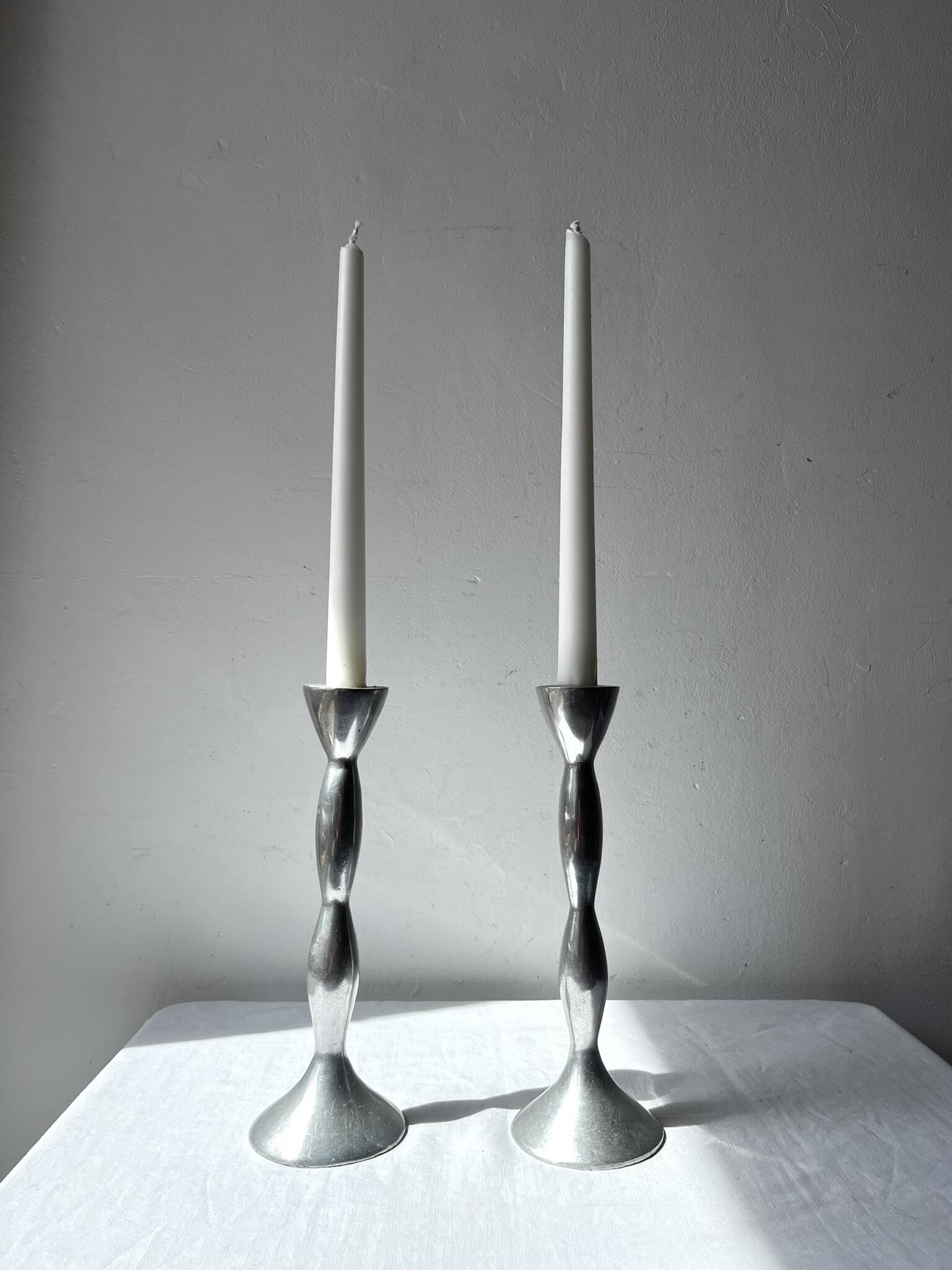Pair of wavy aluminium candle holders