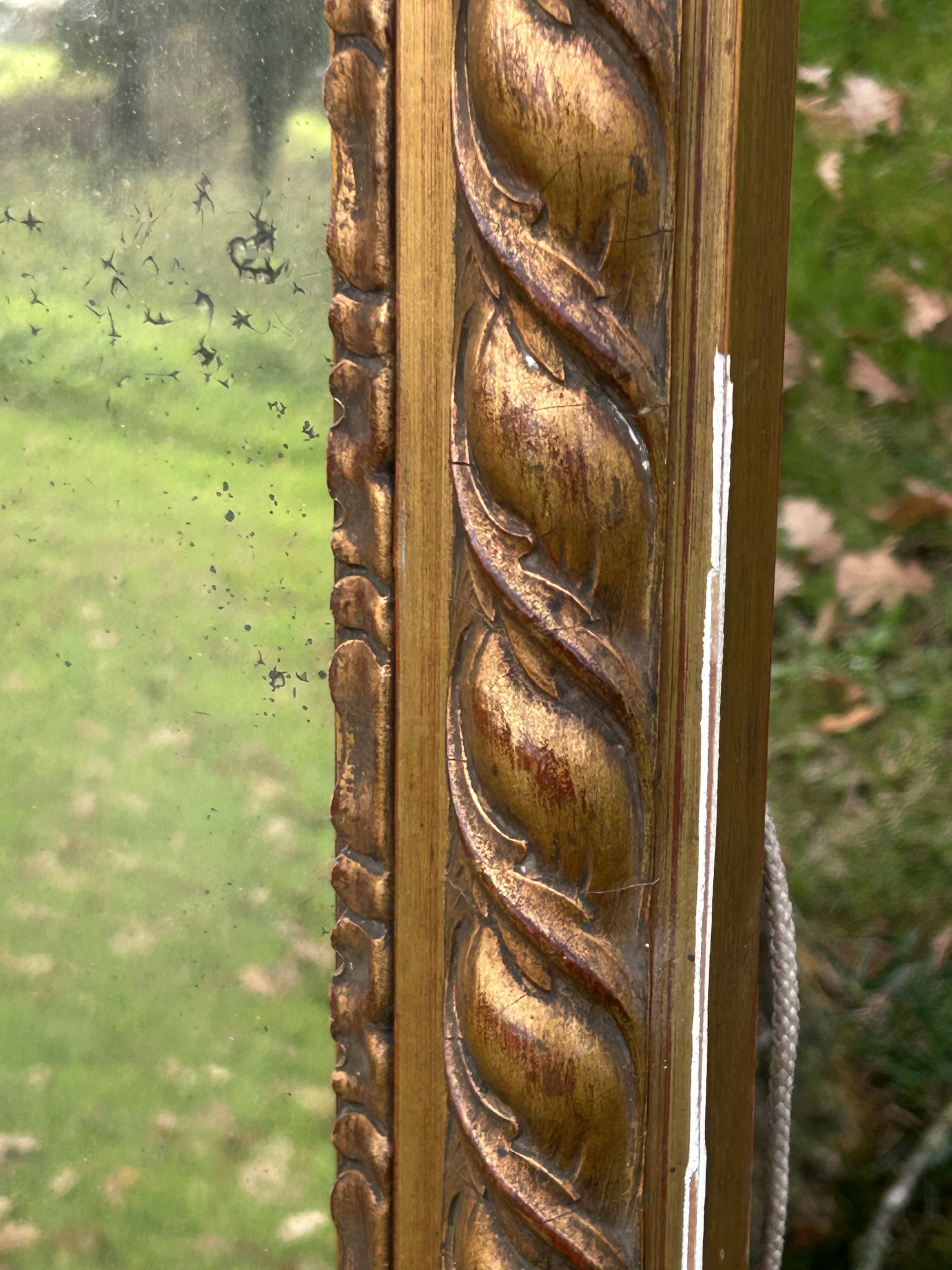 Large antique gilded mirror, wood and stucco gadroons, partially de-mercury