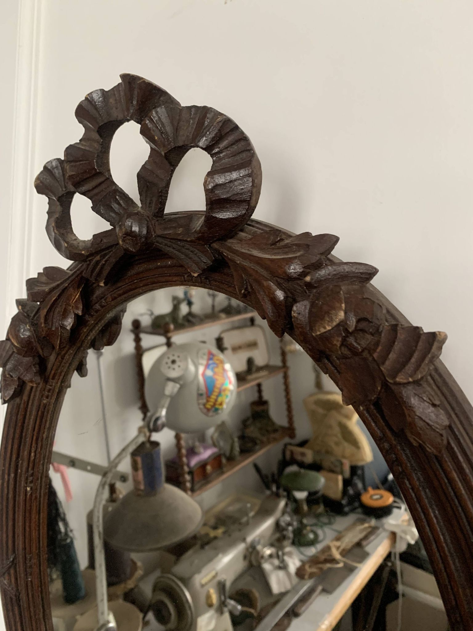 Antique oval mirror in carved wood and Louis XVI style knot